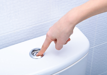 40549538 - finger pushing button and flushing toilet